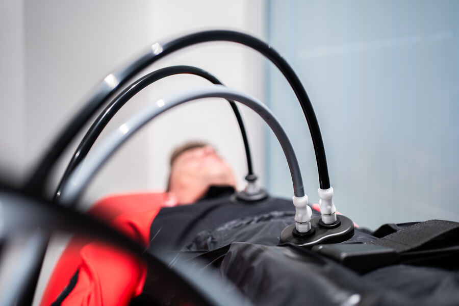 Hypoxi-Anwendung im Anzug auf der Liege