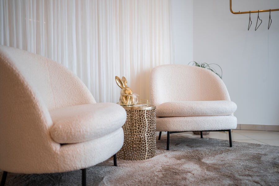 Lounge mit weißen Sesseln und goldenem Hasen